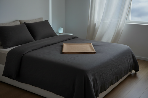 Laku Noc Grounding Sheet folded on dark linen bedding